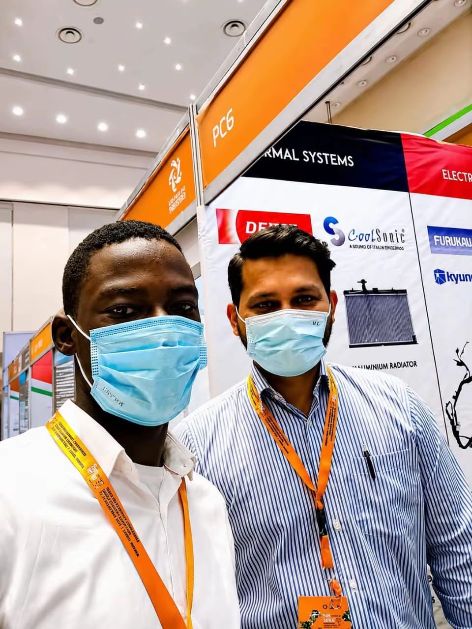Rotimi Okanlawan with an international associate at an automotive parts exhibition